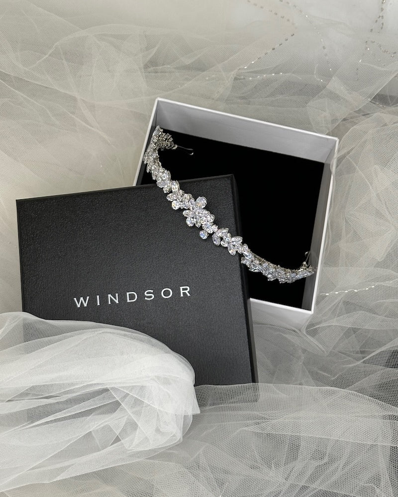 A narrow Bridal Crown in a display box resting on a black lid