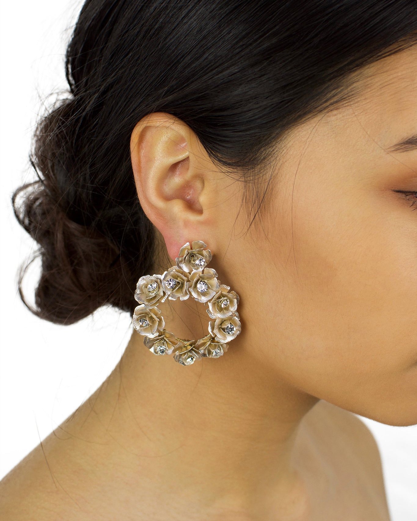 Ring of pale gold flowers earring worn by a bride with up style hair