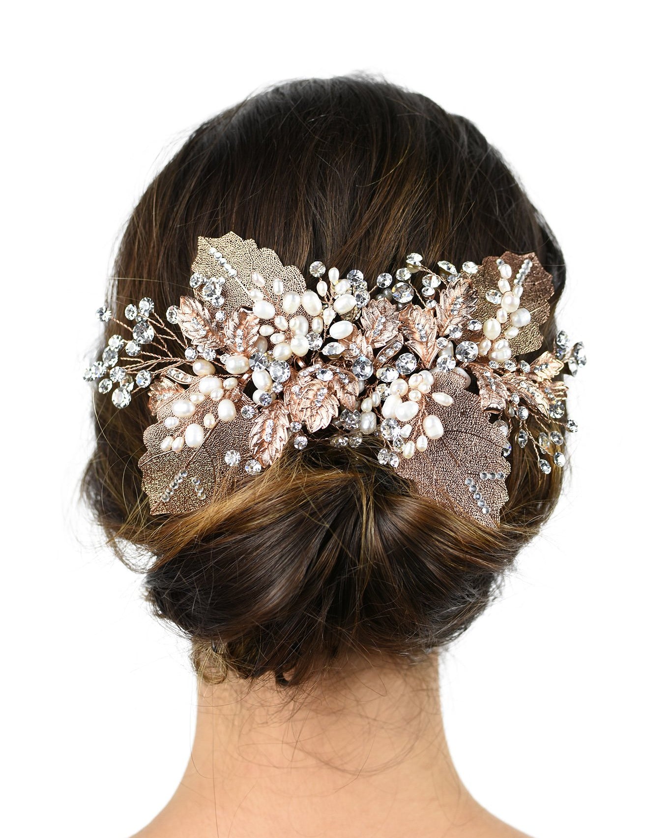 Brown hair model bride wears a large leaves bridal headpiece at the back of her head on a white background