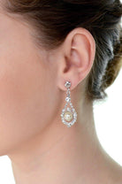 A models' ear wears a pearl drop earring against a white background