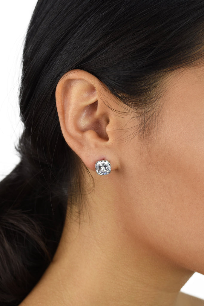 Square shape crystal stud earring with rounded edges worn in the ear of a model