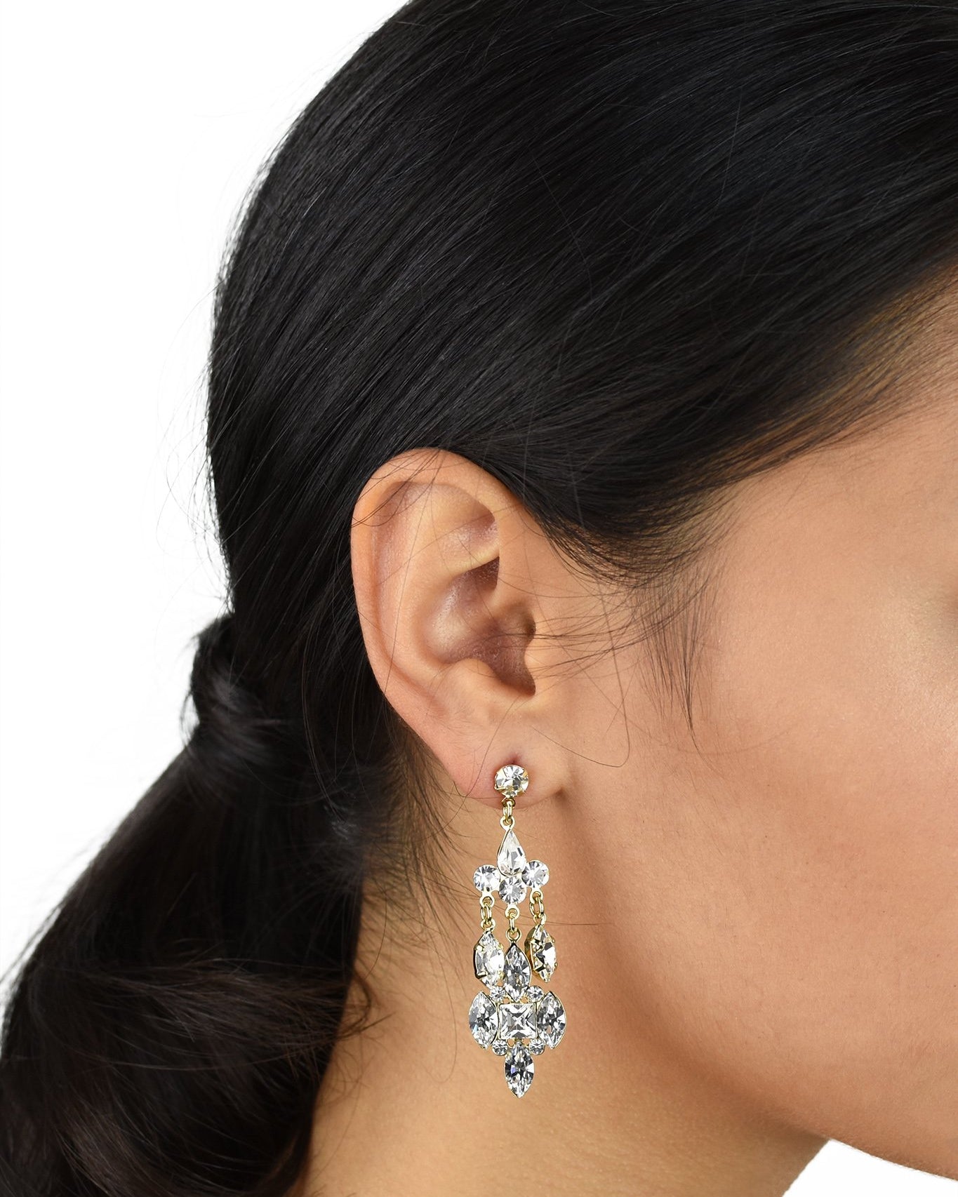 Dark haired Bride wearing a mid length silver drop earring with a post fitting on a white background.