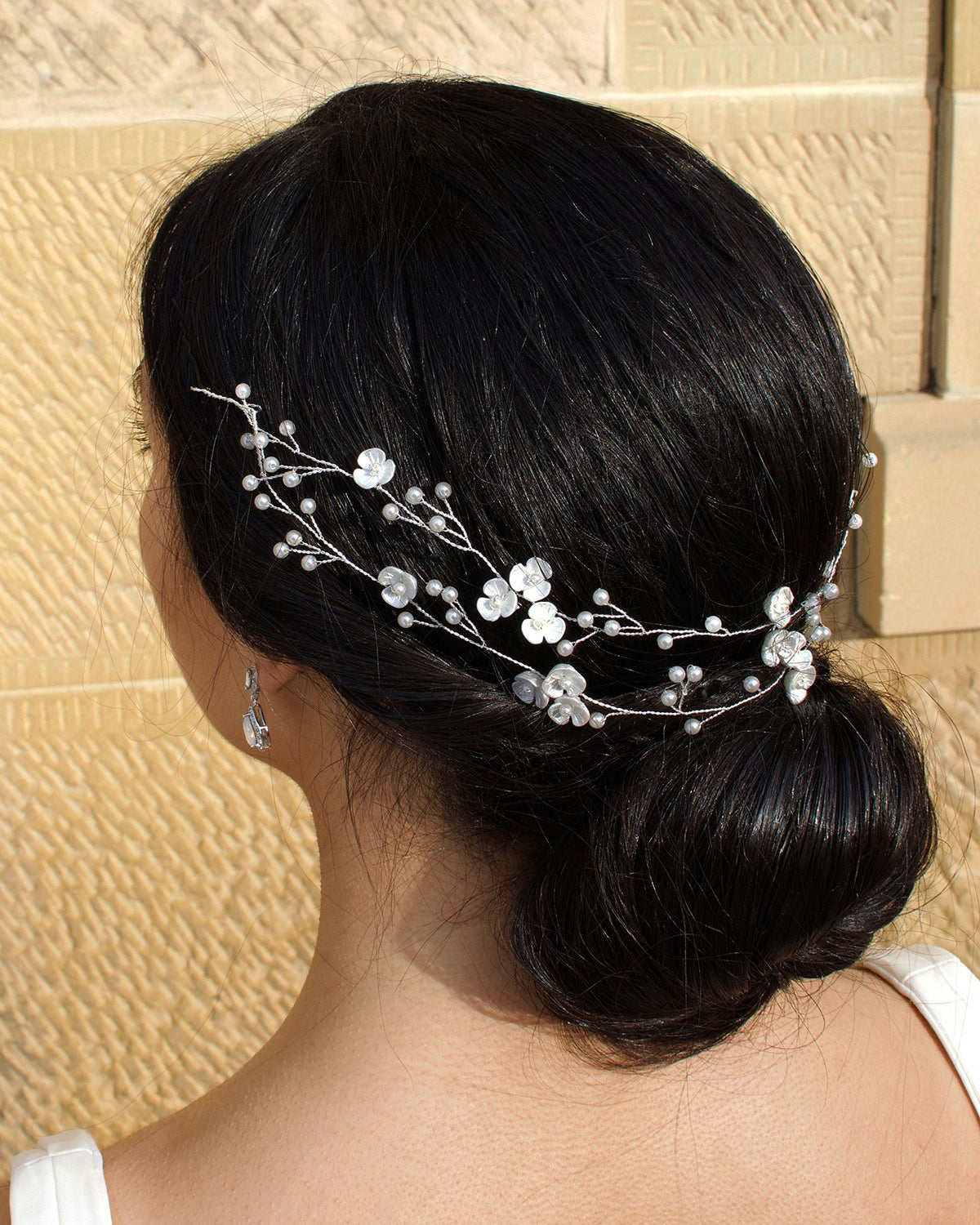 Double row silver and pearl vine on a dark haired model with a stone wall backdrop