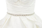 A narrow pearl bridal belt with rings of crystals around the pearls is worn on an ivory bridal gown