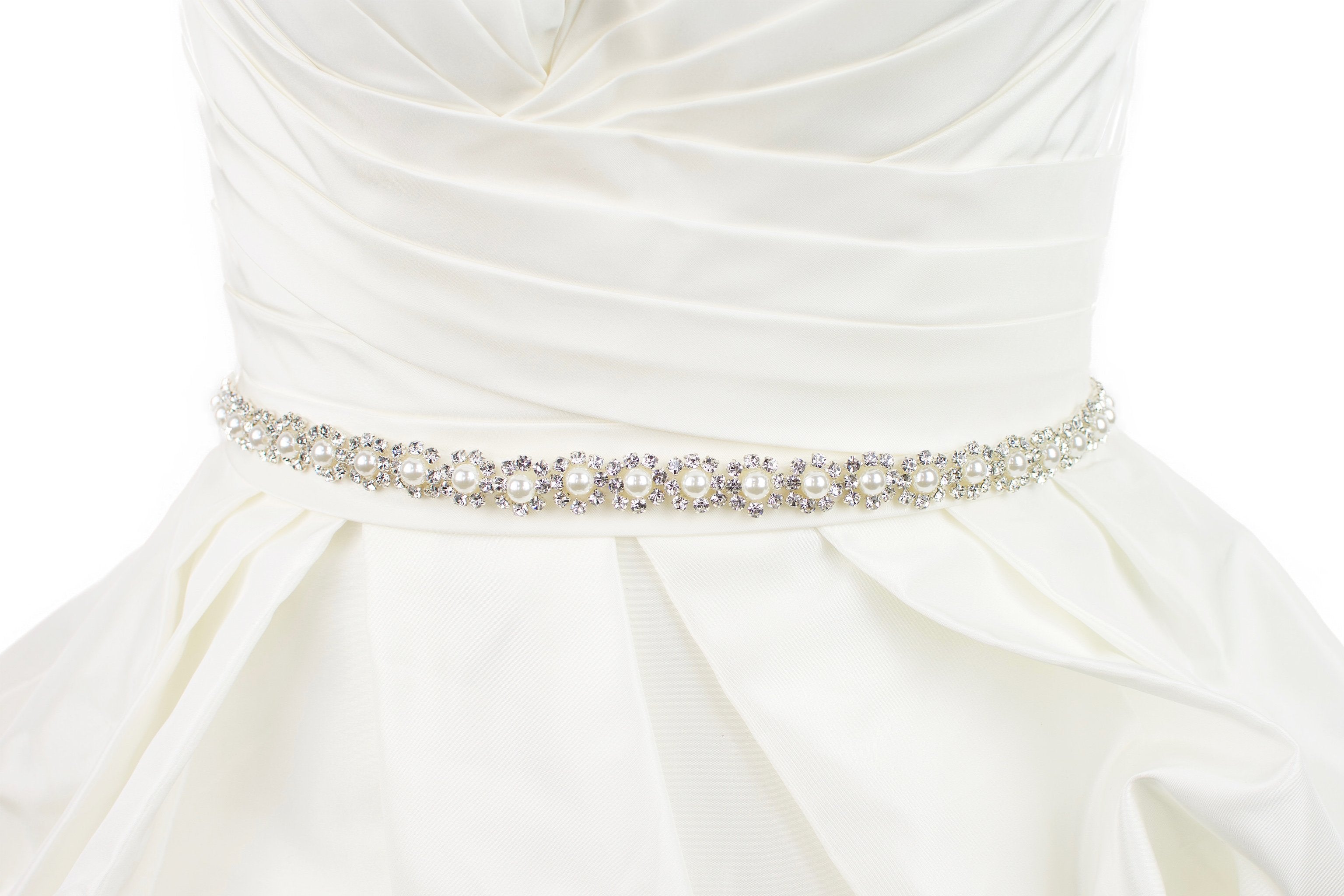 A narrow pearl bridal belt with rings of crystals around the pearls is worn on an ivory bridal gown