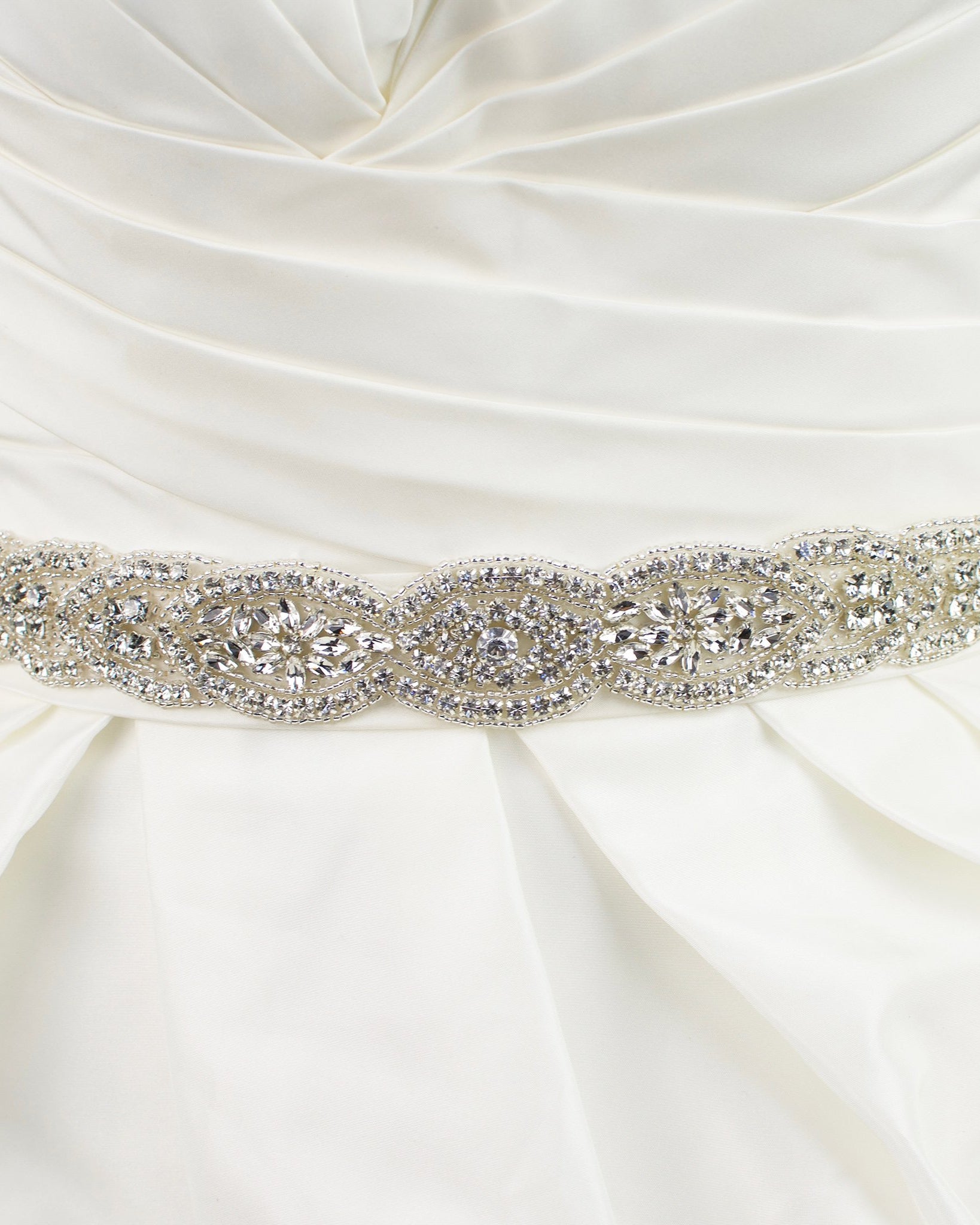 Silver Bridal belt full of shining stones worn on an ivory bridal gown with a white background