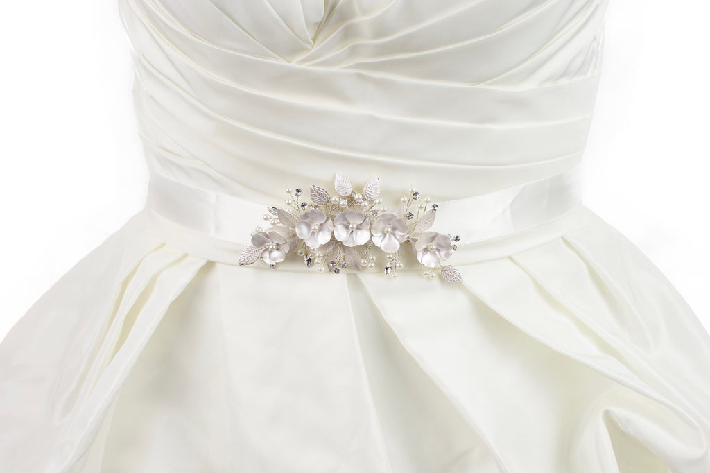 Soft pale pink metal flowers belt on ivory satin ribbon worn on a bridal gown