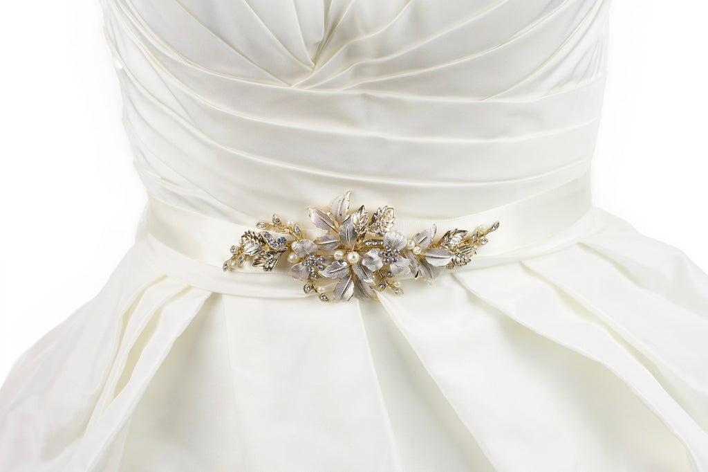 Pale Gold leaves and flowers motif on an ivory satin ribbon worn on an ivory bridal gown. 