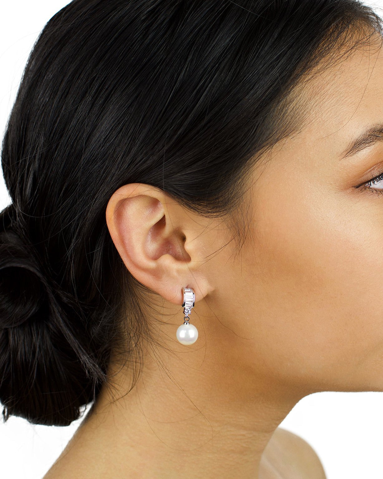 Small pearl earring with clear stones worn by a dark haired bridal model