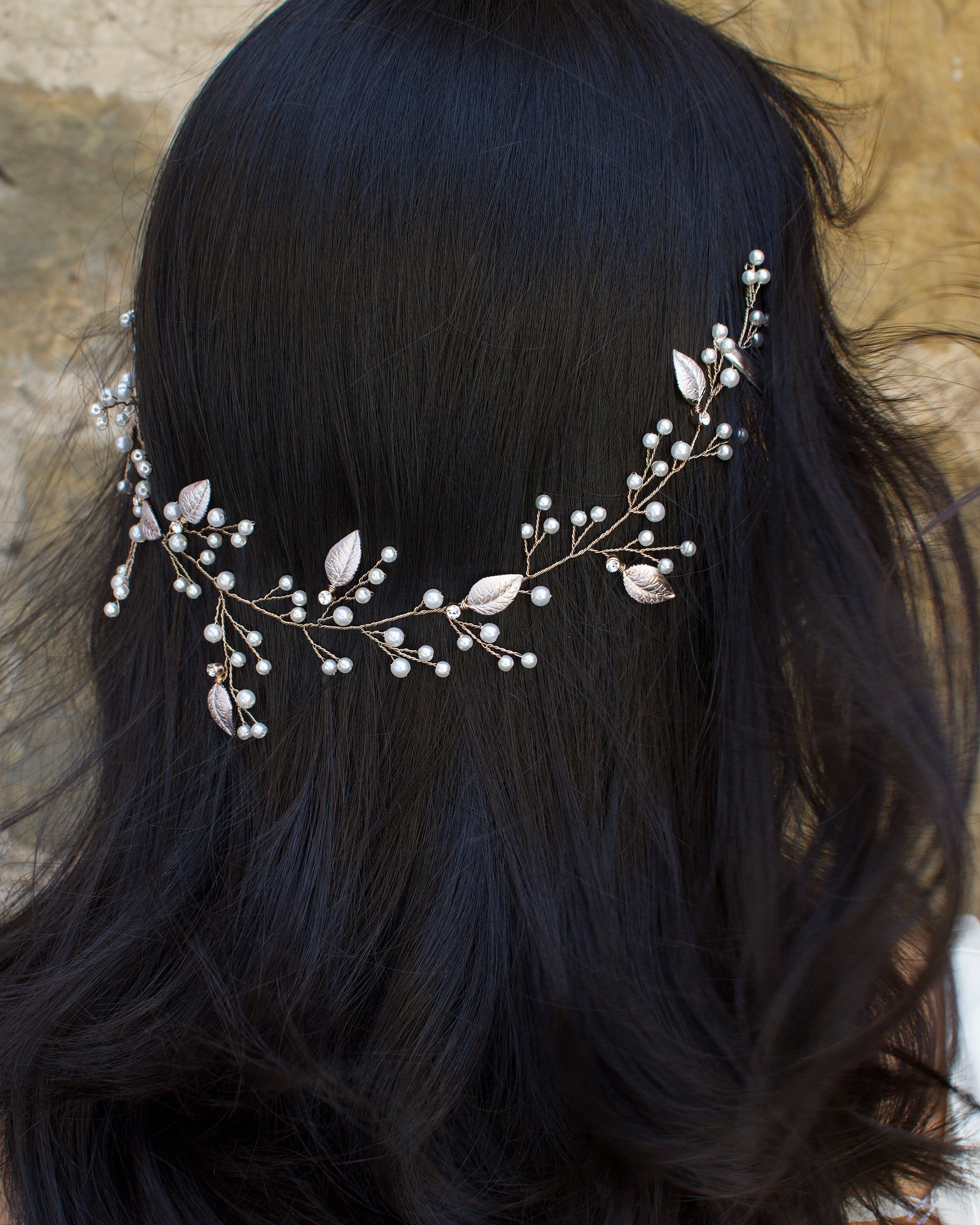 A dark haired Bride wears a thin wire Bridal Vine with leaves and pearls.