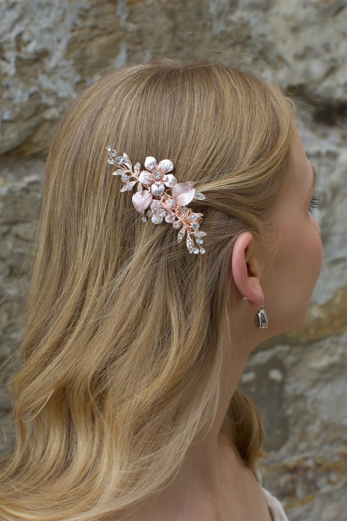 Pale Rose Gold clip worn by a blonde bride in front of an old stone wall