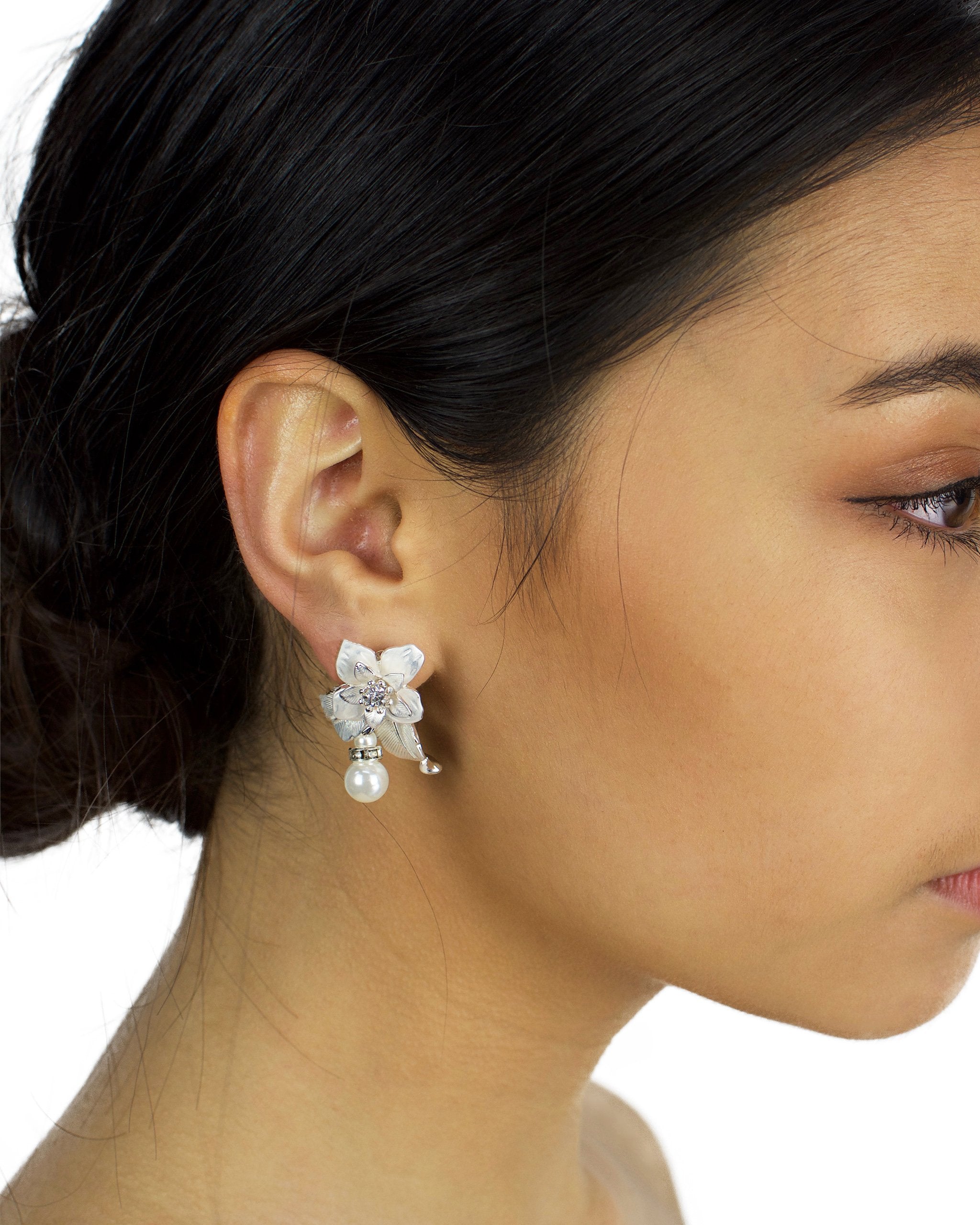 Flower and pearl soft silver earring worn by a dark haired bridal model