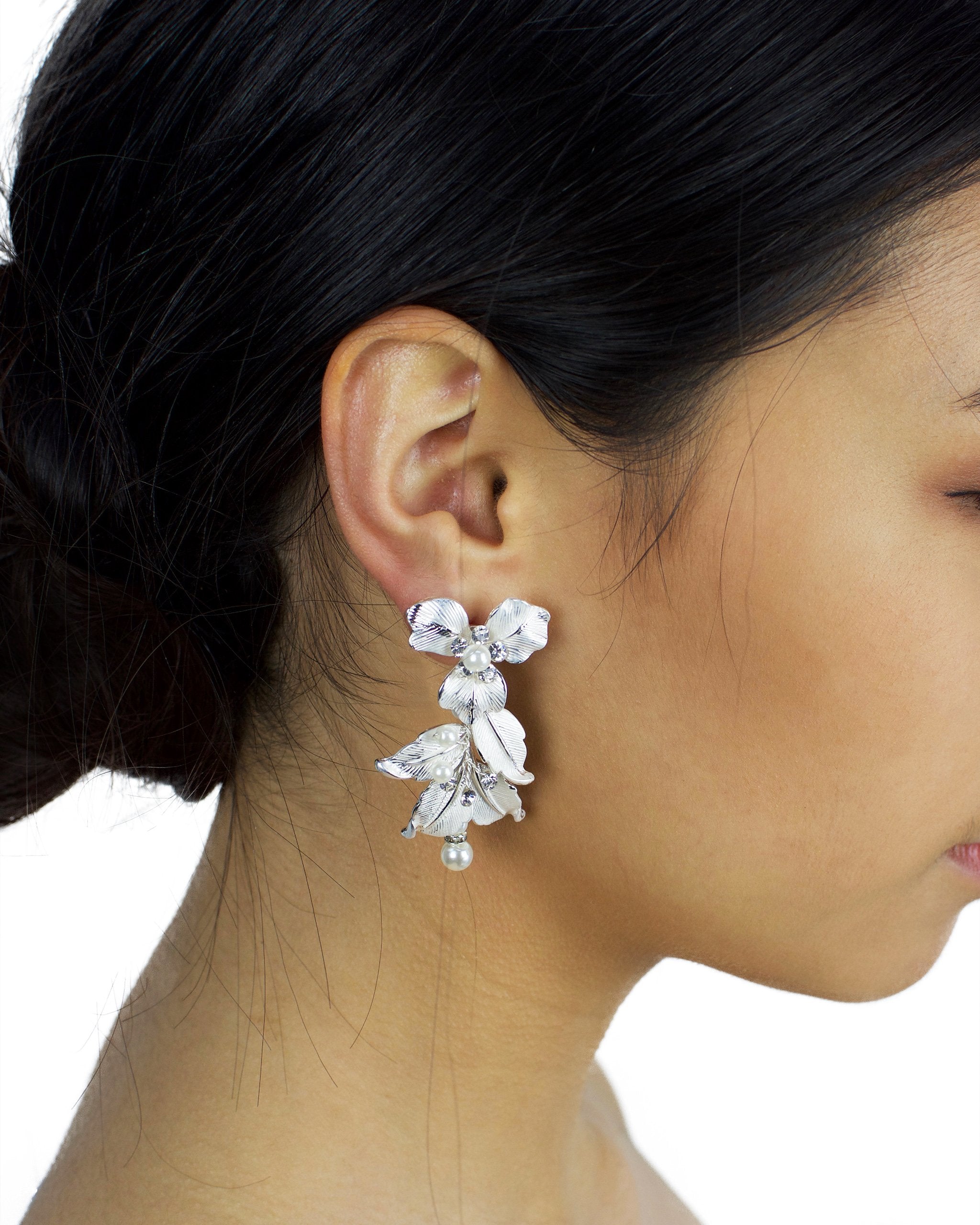 Silver Statement Bridal earring with flowers and white effect worn by a bride with dark hair
