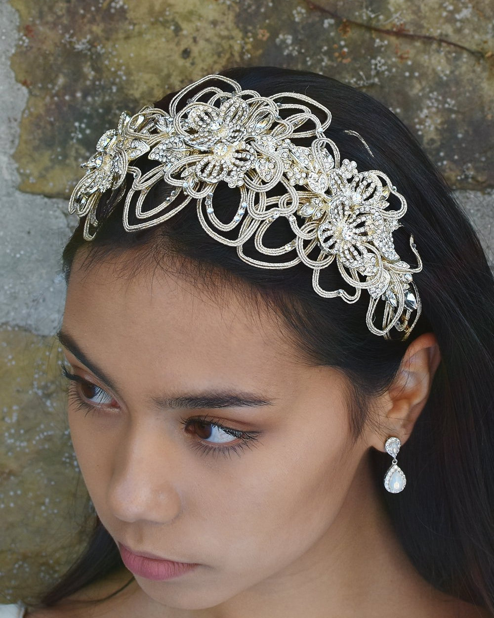 Matt Gold Headband worn at the front of the head on a black hair model with a stone wall behind
