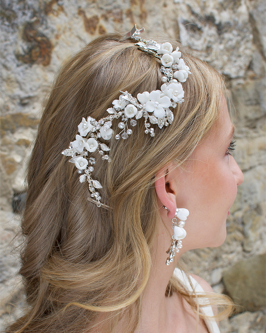 Blonde haired girl wears ceramic white flower and leaf vine.