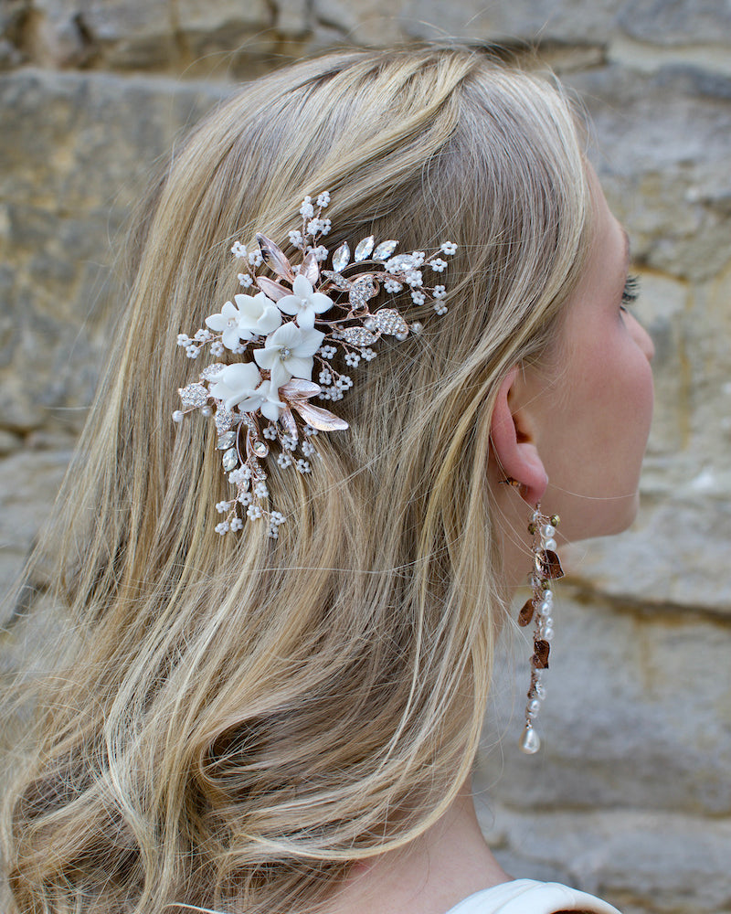 Pale Rose Gold bridal side clip with Porcelain flowers and pearls worn by a blonde model on the side of her head