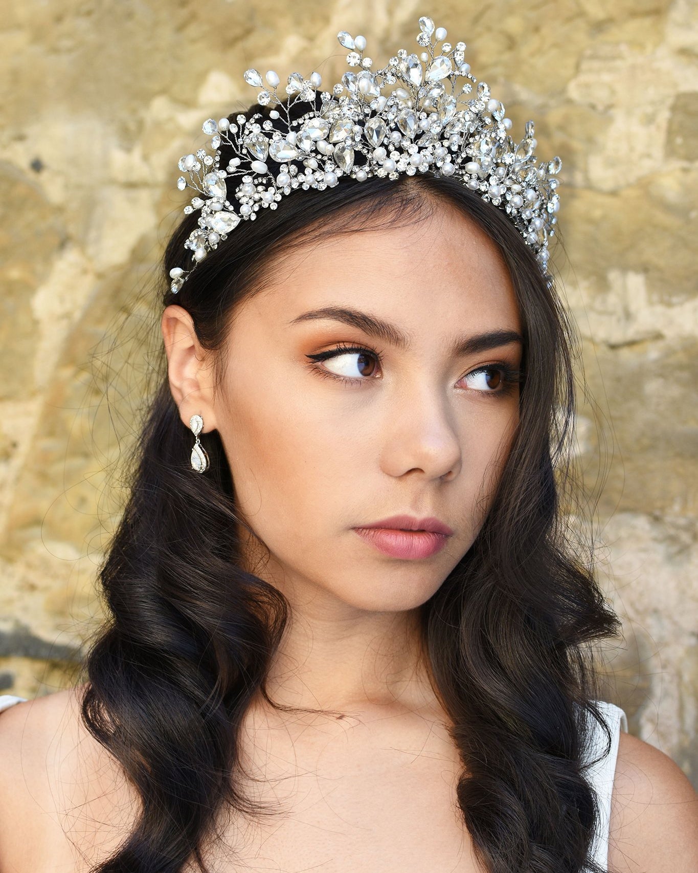 A Bride wears a high Tiara of pearls and Swarovski Crystals on her dark hair