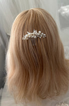 Blonde hair with a decorative hair comb featuring pearls against a neutral background