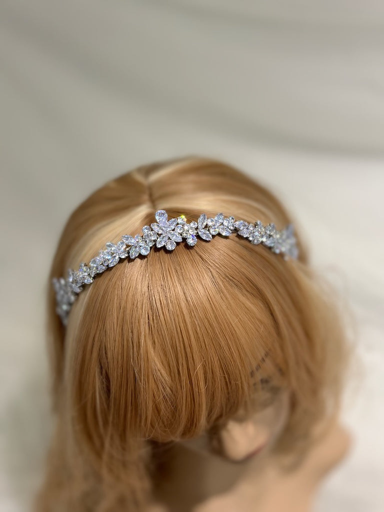 a narrow silver crystal headband worn on a model head