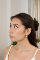 Close-up of a woman wearing diamond earrings with a blurred background