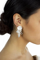 Silver hand painted earrings with pearls worn by a dark haired model bride