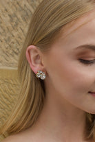 Clear stones in a gold hand made earring worn by a blonde model bride