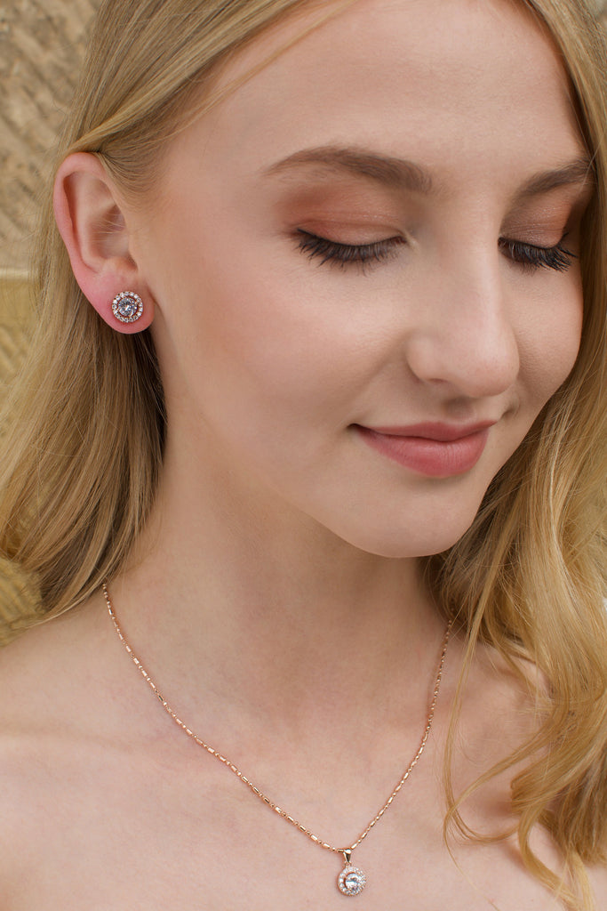 Close up of a model wearing a rose gold stud earring and a rose gold simple pendant 