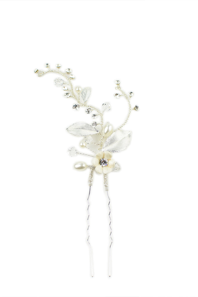 A silver hairpin with a small ceramic flower on a white background