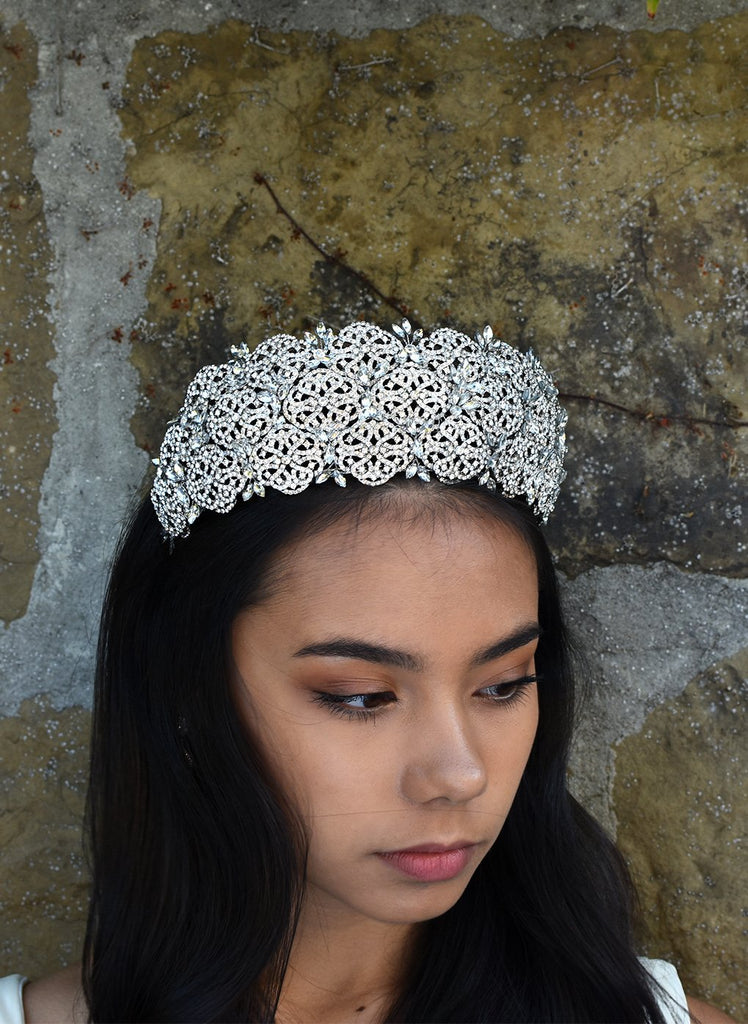 Very high Bridal Tiara with hundreds of tiny crystals worn by a dark hair bride with a stone wall backdrop