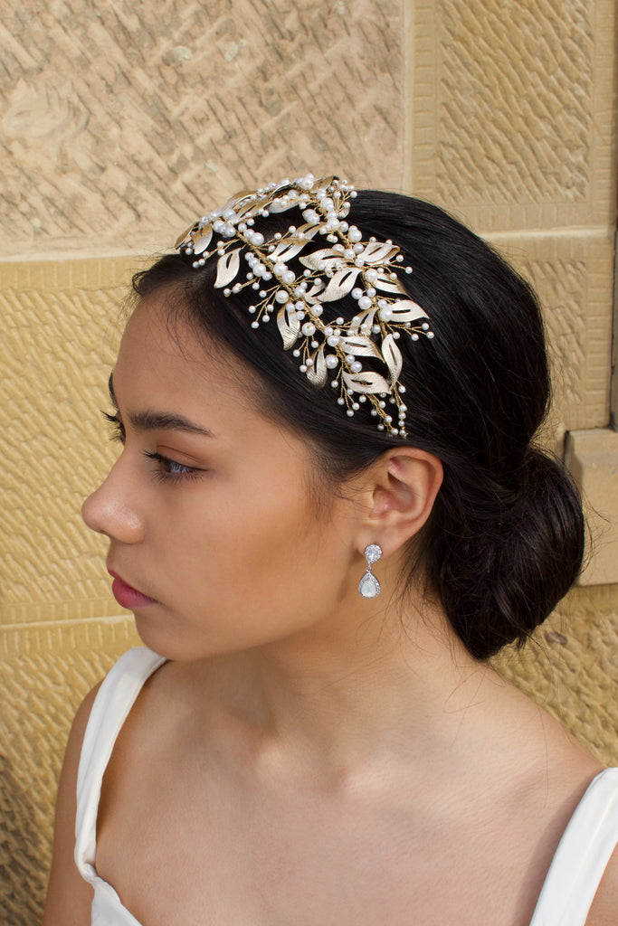 Side View of Double row pale gold headband with pearls worn by a dark hair model with a sandstone wall