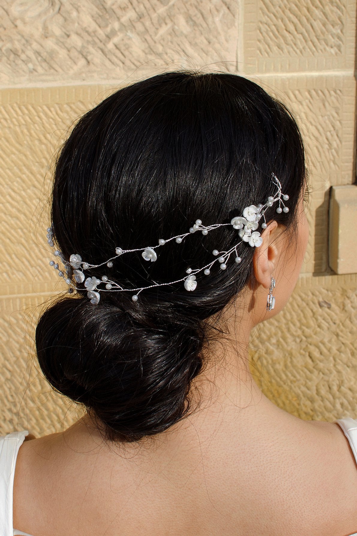 Twin row vine in silver worn by a dark hair model with a sandstone wall backdrop