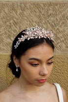 Pale Rose Gold Flowers and Leaves Tiara with pearls worn by a dark hair bride in front of a stone wall