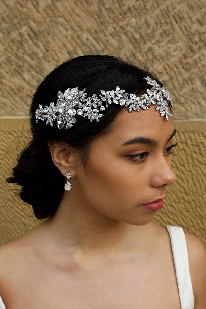 Dark Silver vine of leaves encrusted with tiny crystals worn across the forehead of a dark haired bride with a stone wall behind