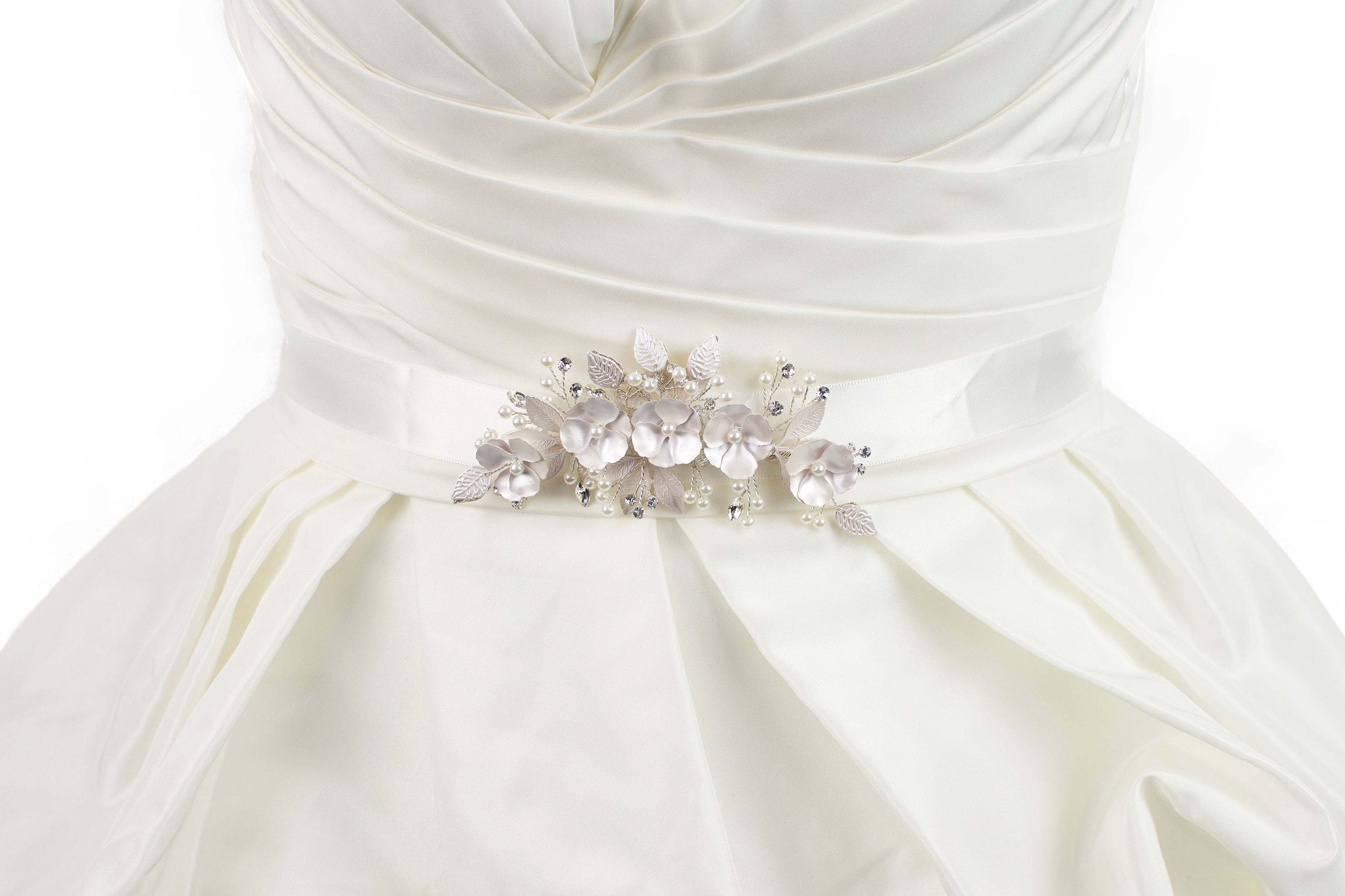 Soft pale pink metal flowers belt on ivory satin ribbon worn on a bridal gown