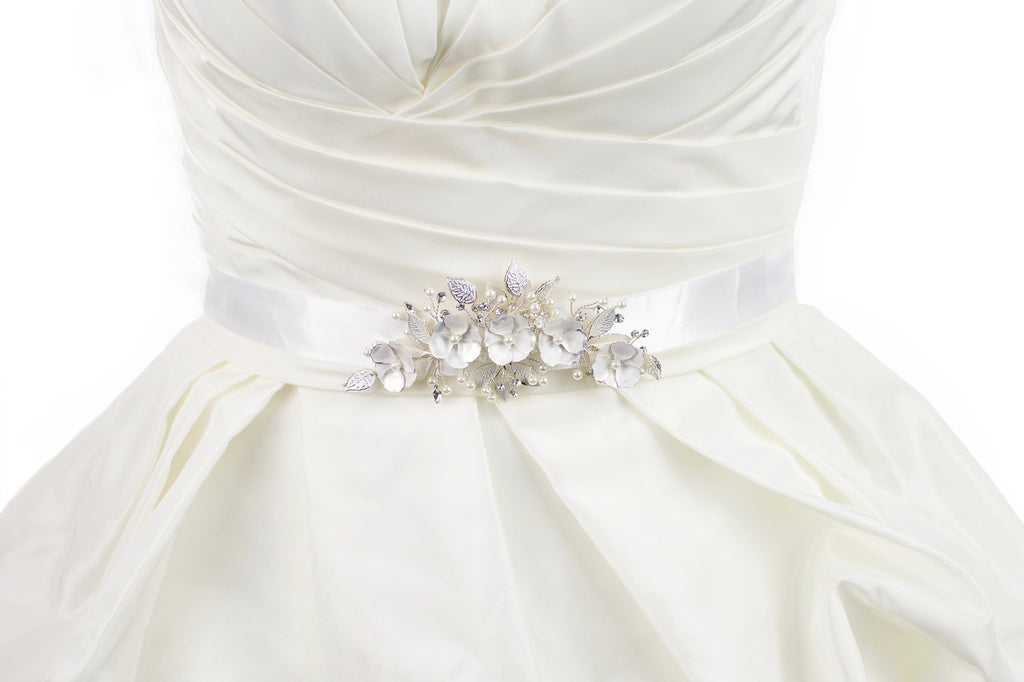 Soft white hand painted flowers on a bridal belt worn on an ivory satin gown