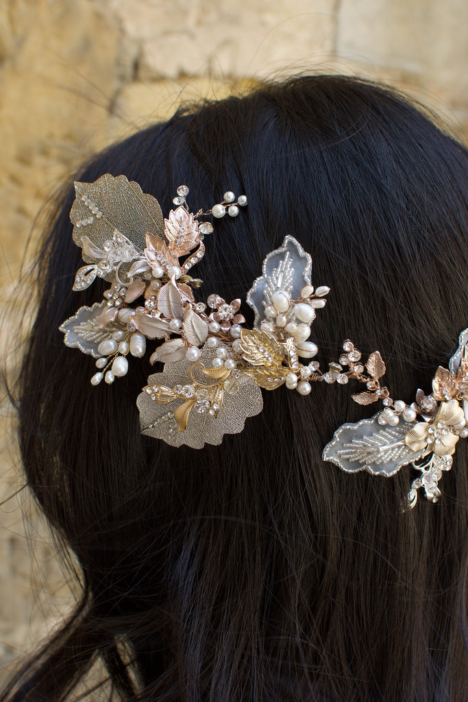 A dark haired model with hair down wears a Bridal Vine in Silver, Gold and Rose Gold with a background of a stones