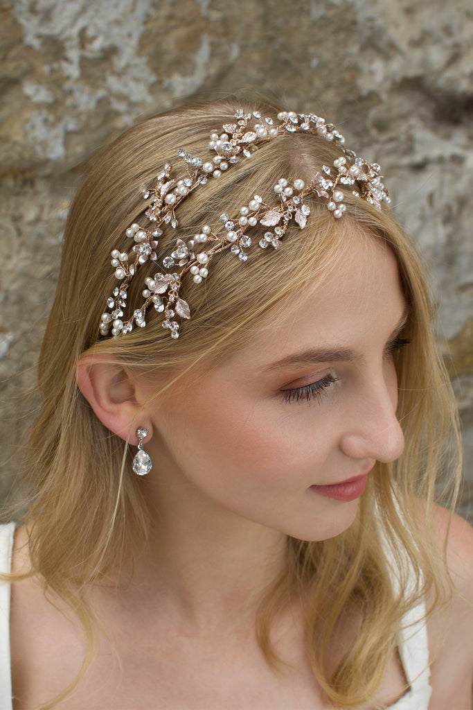 Double row headband in rose gold worn by a blonde model with a stone wall background