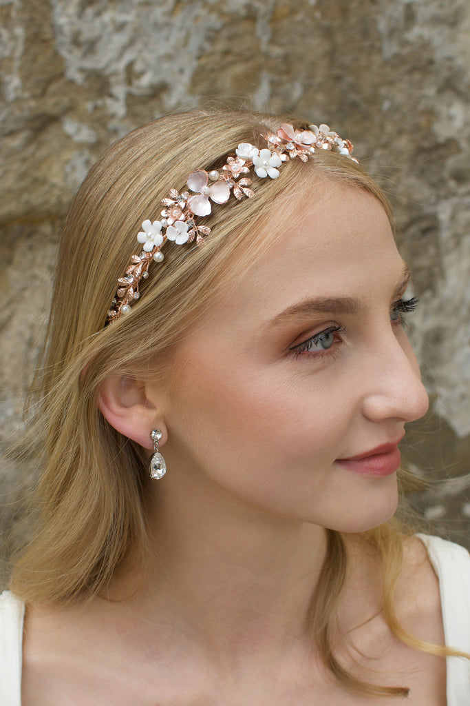 Blonde Bride wearing a pale Rose Gold headband with flowers with a stone background