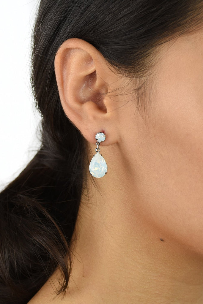 Dark hair model wears a silver earring with a white opal stone