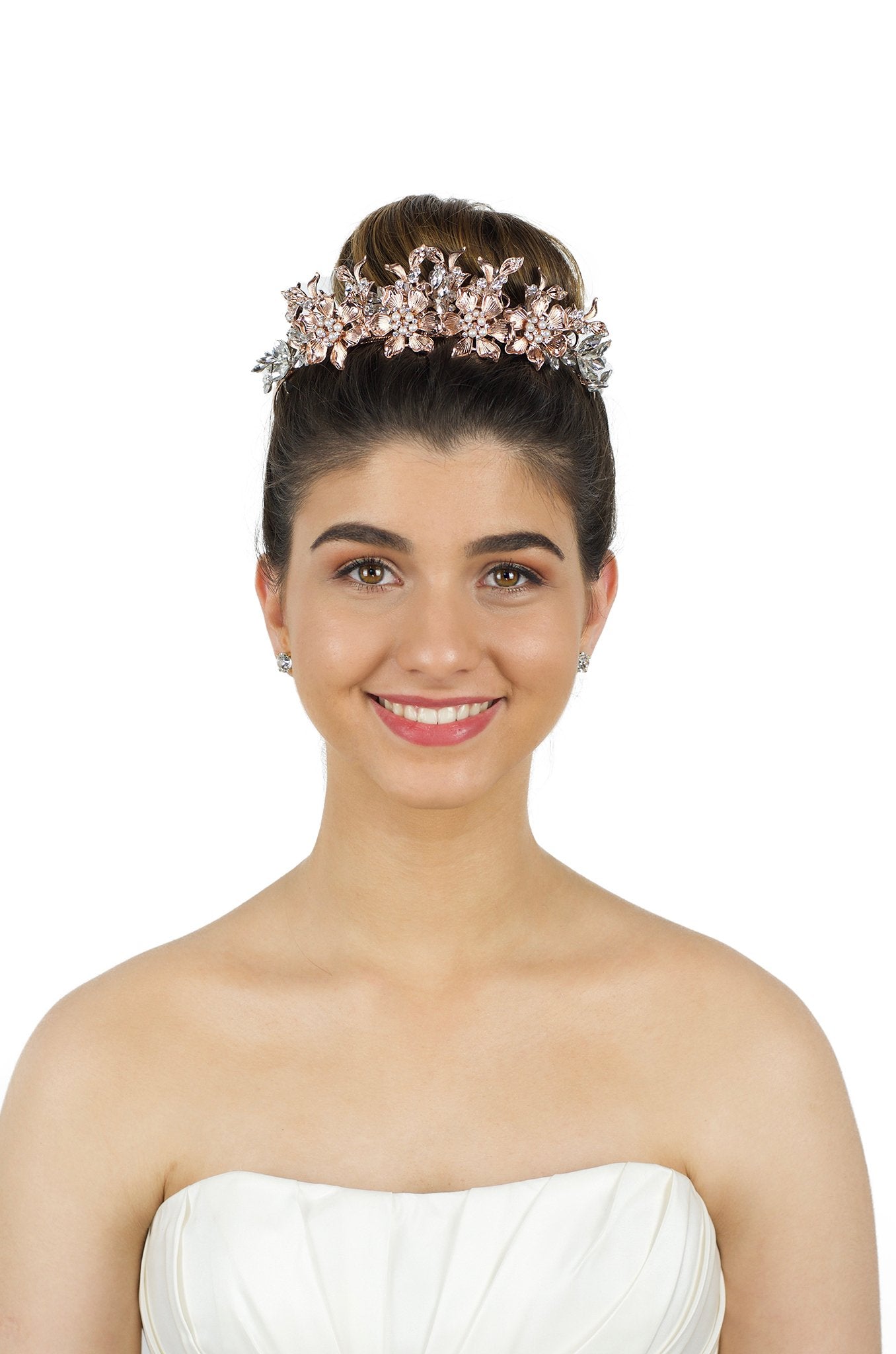 Pale Rose Gold Tiara of flowers and leaves worn by a smiling dark hair bride in front of a white backdrop