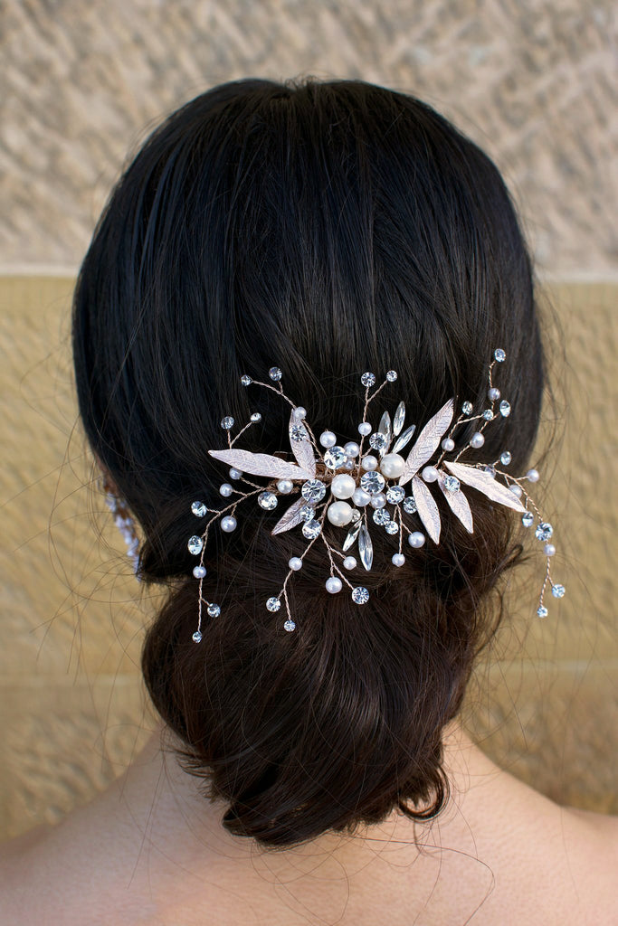 dark hair model wears a comb with pearls and leaves at the back of her head