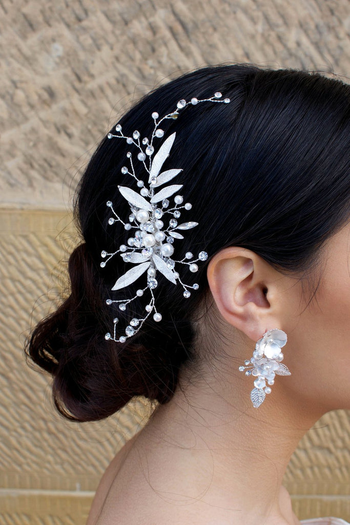 Dark hair Bride wearing a silver and leaf comb at the back of her head with a matching earring.