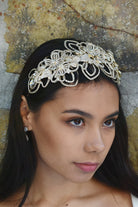 Matt Gold Bridal Headpiece worn by a dark hair model with a stone wall behind her. 