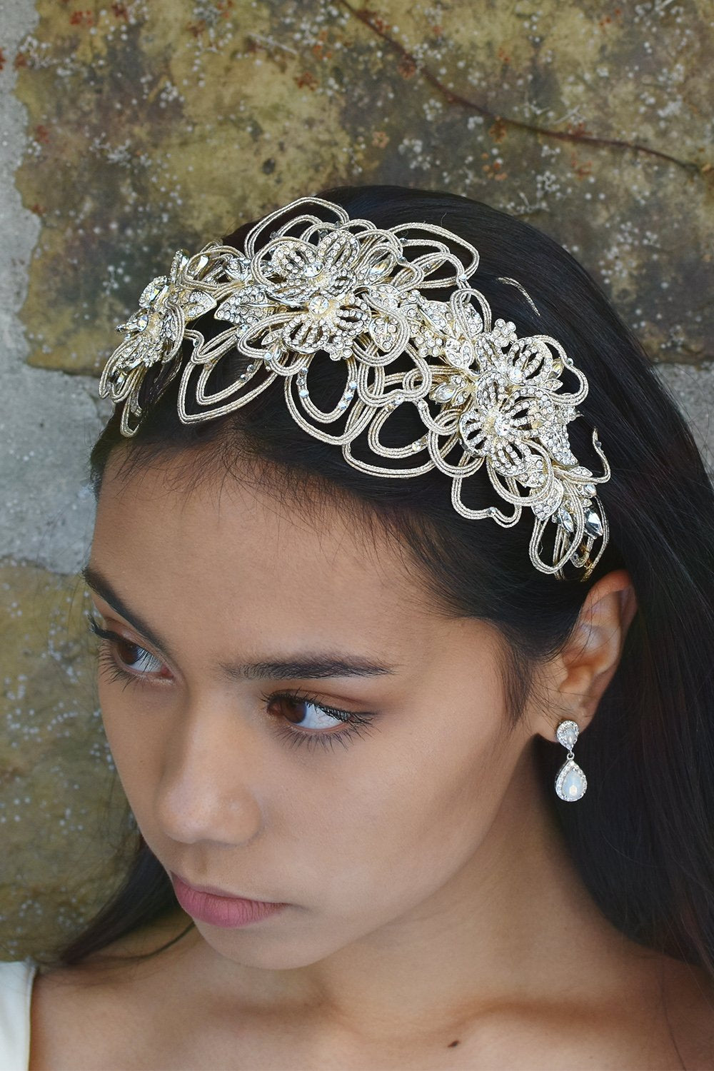 Matt Gold Headband worn at the front of the head on a black hair model with a stone wall behind