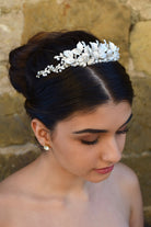 Dark haired bride wears a low silver tiara with a stone wall background